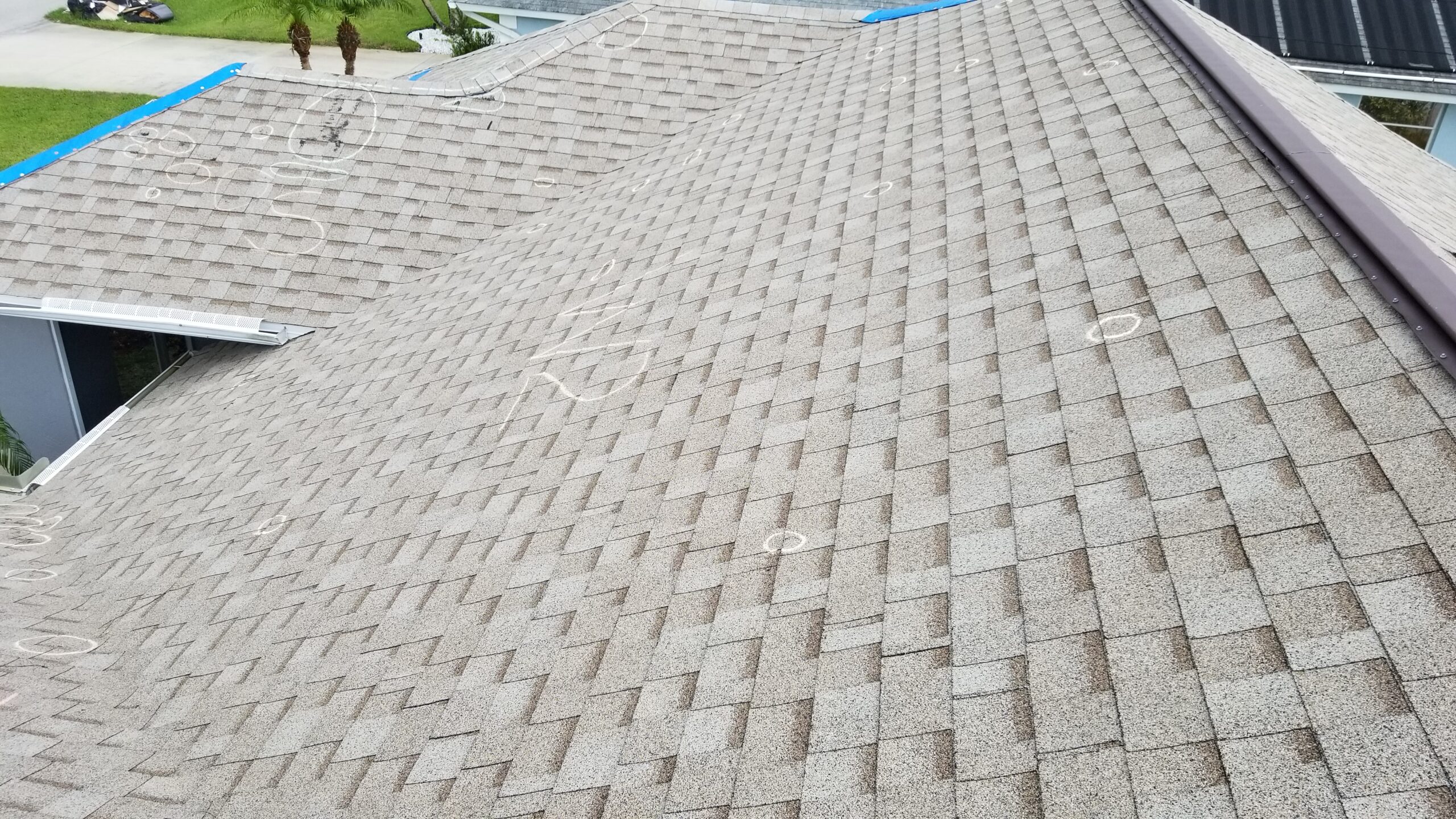 Close-up of detailed roof inspection after hurricane damage, showing shingle-by-shingle documentation.