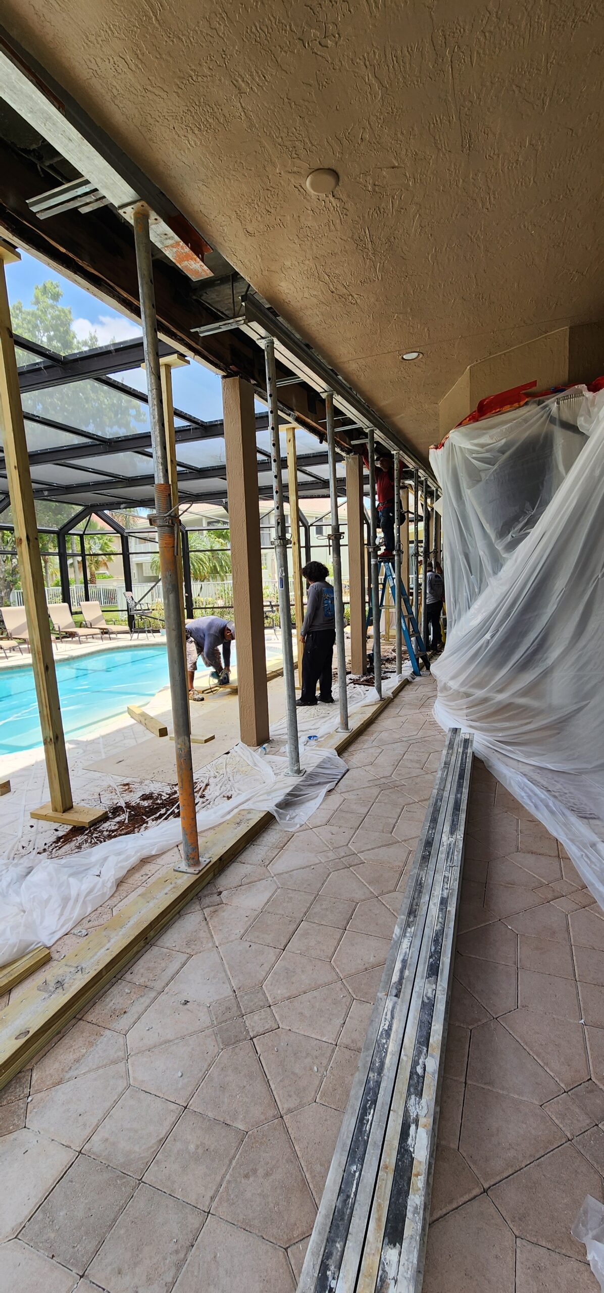 Balcony repair in progress with stucco cut back to expose corroded steel reinforcement.