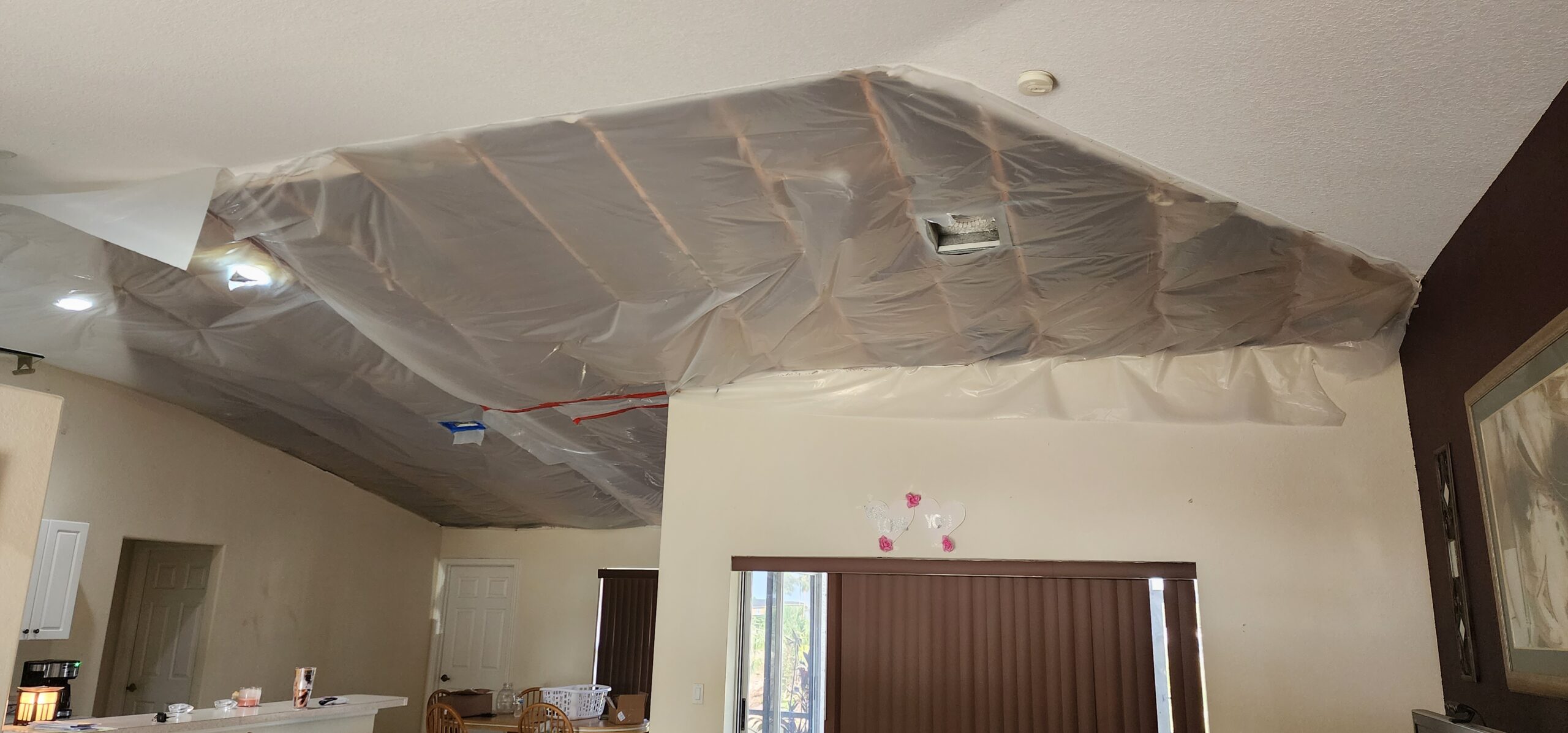 Ceiling damage after hurricane winds entered through soffits and vents, blowing out interior ceiling panels.