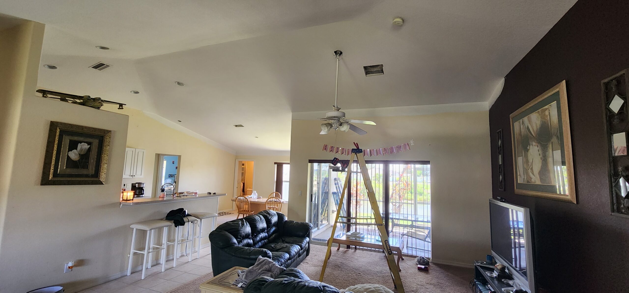 Restored interior ceiling after hurricane damage, with new drywall, vents, paint, and texture completed.