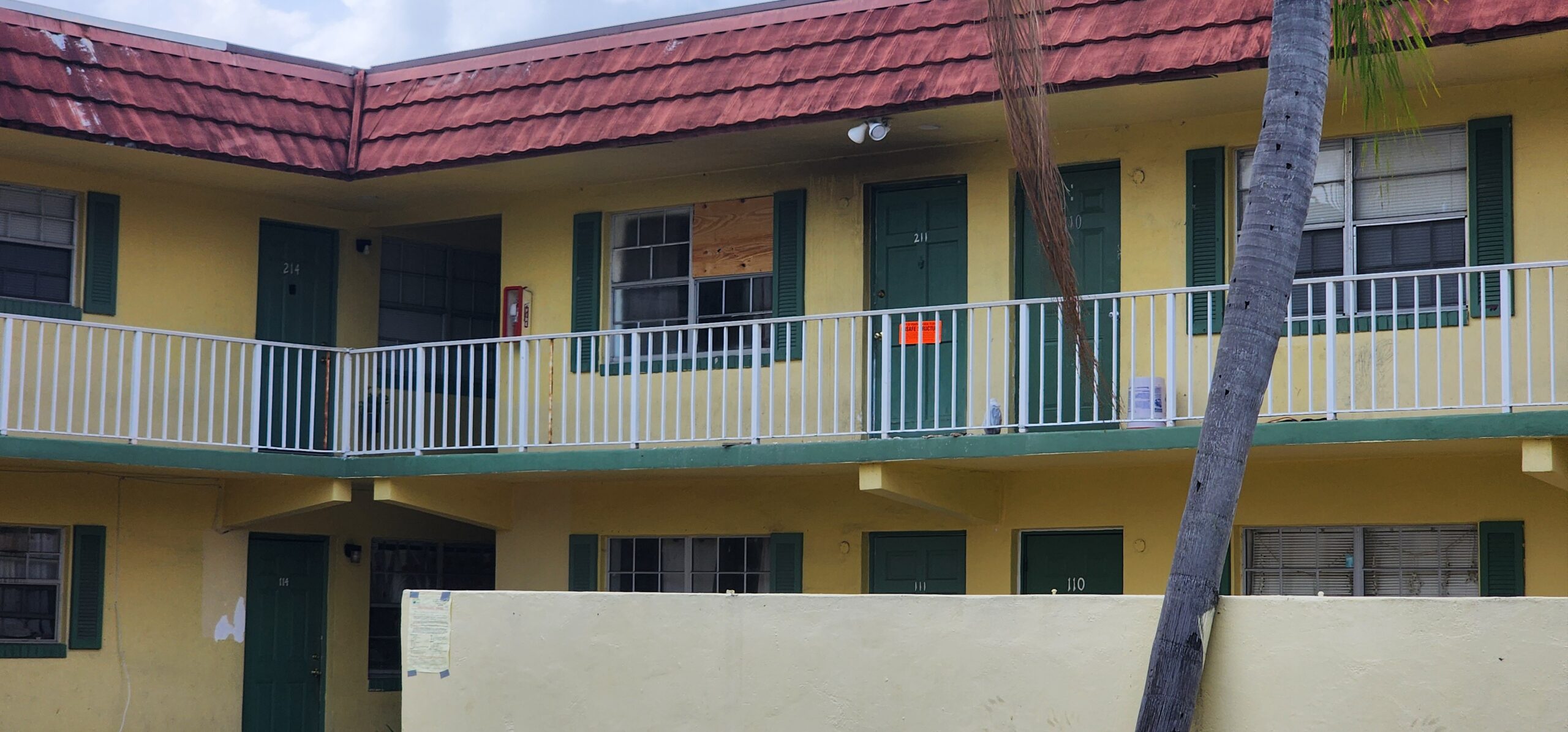 Exterior of apartment building with visible fire-damaged unit.